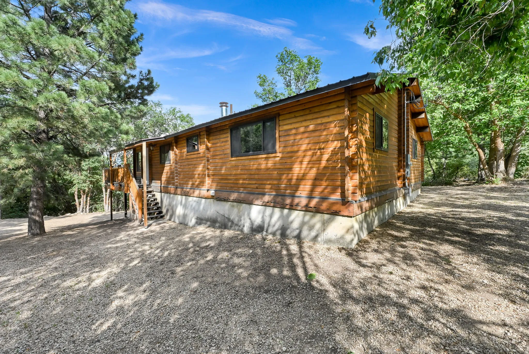 Wood-sided exterior with a gravel perimeter and covered entry
