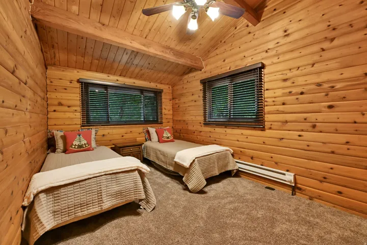 Wood-paneled room featuring vaulted ceilings with exposed wood beams