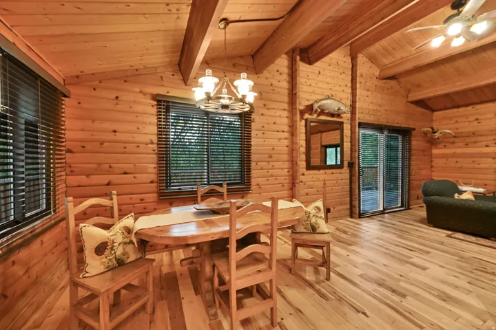 Wood-paneled interior featuring vaulted ceilings with exposed beams and light wood-finish flooring