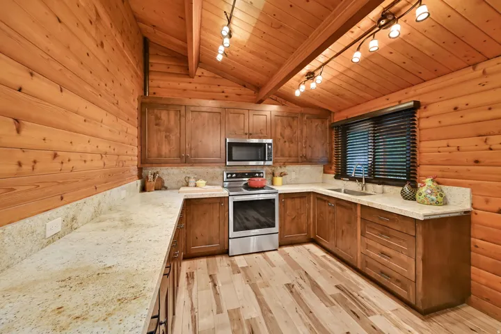 Kitchen featuring wood-paneled walls and vaulted ceilings