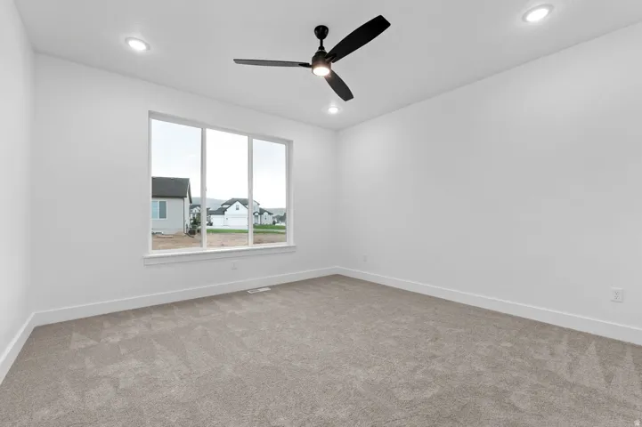 Bright interior space featuring a large three-panel window, recessed lighting, and a modern ceiling fan
