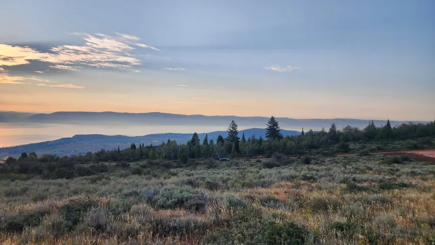 Expansive natural landscape featuring rolling hills and distant mountains