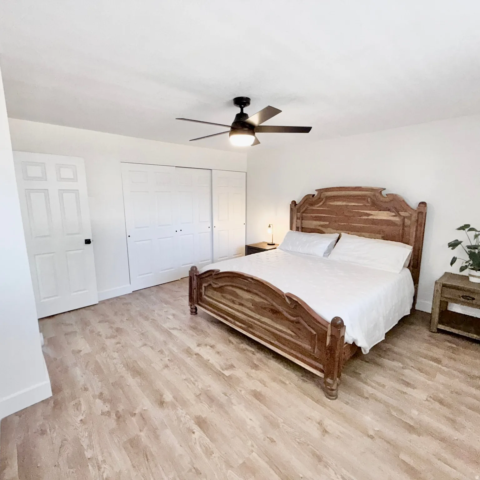 Master Bedroom, wood-finish flooring, white paneled door, and a ceiling fan with integrated lighting