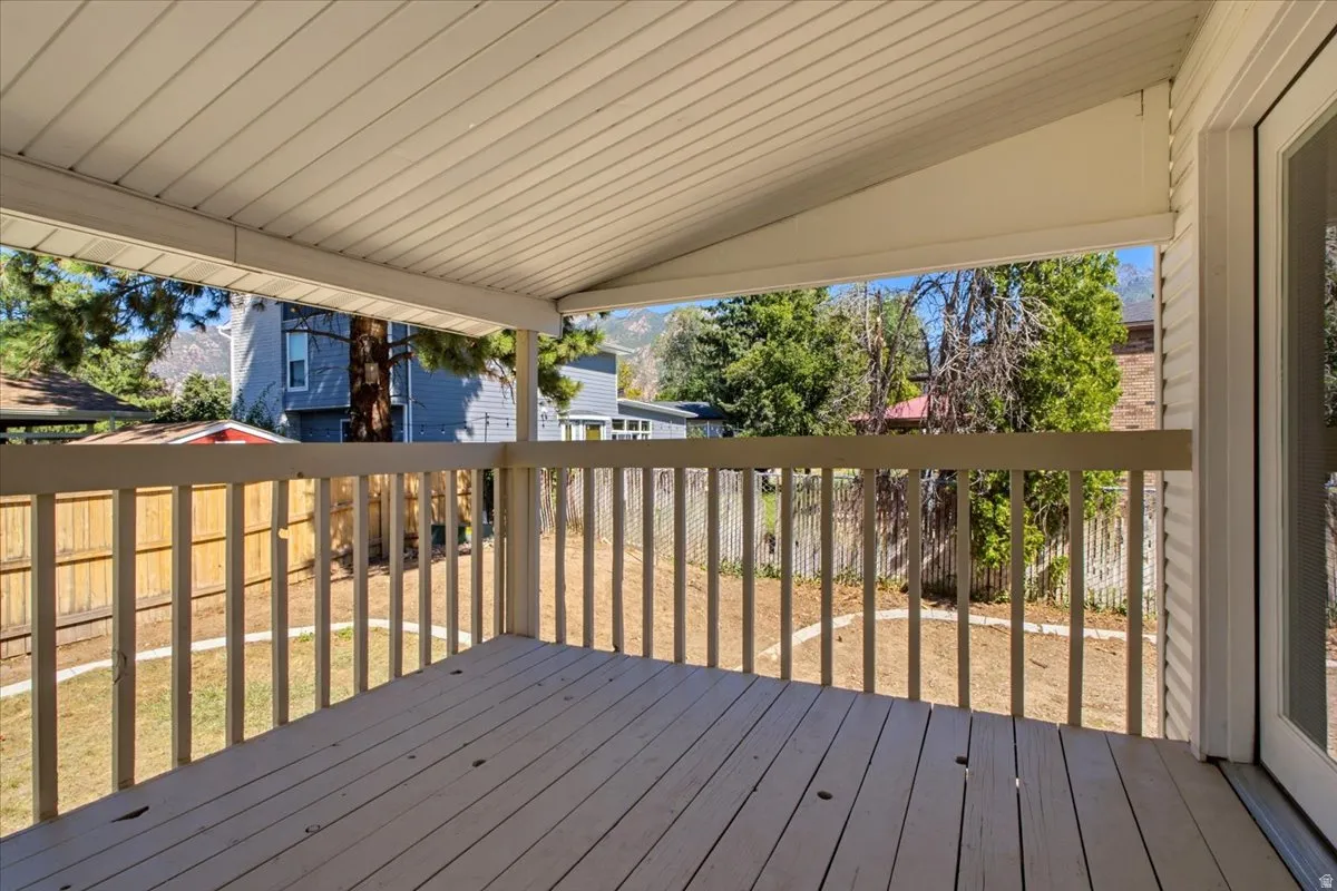 Covered outdoor deck with painted wood flooring and perimeter railing