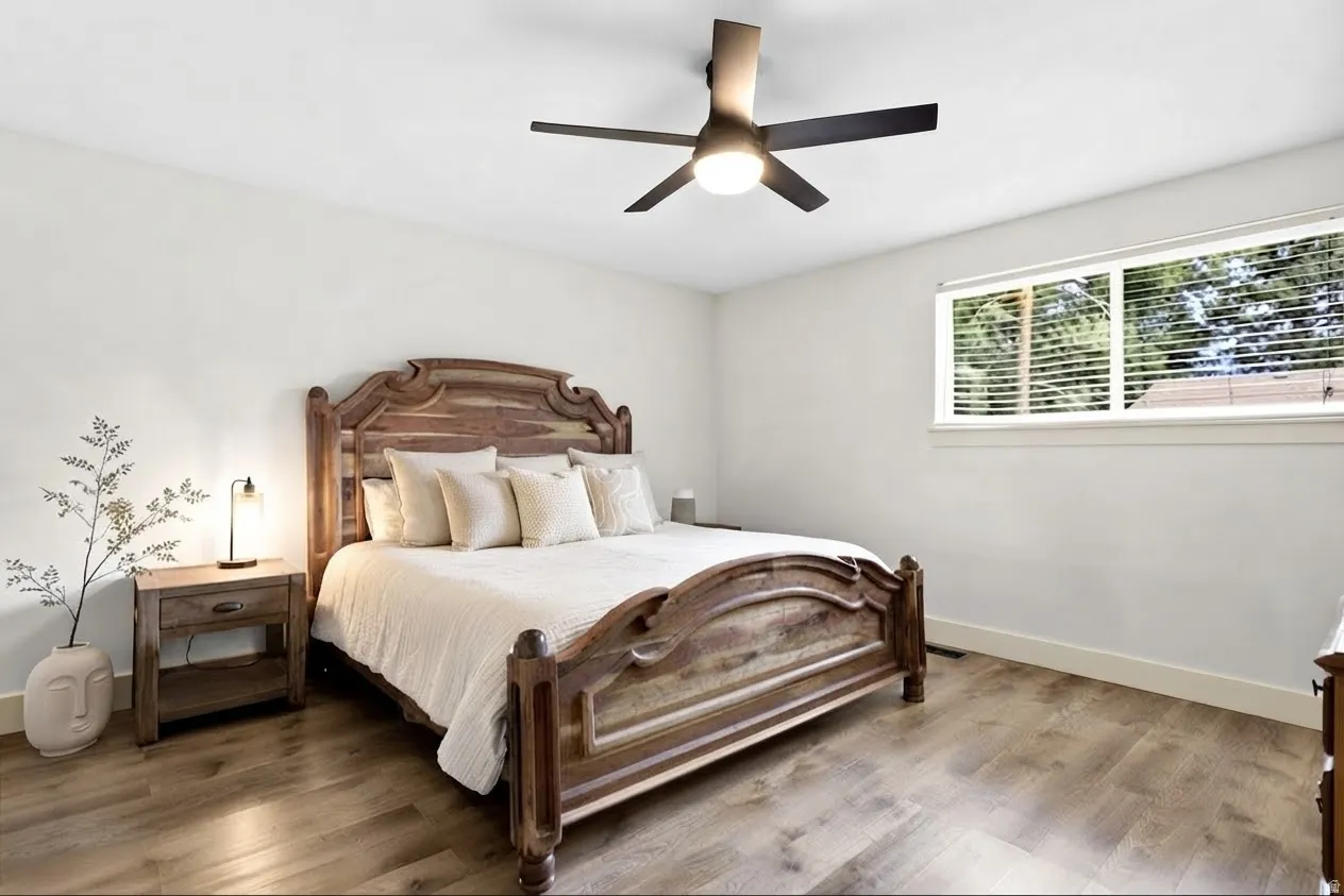 Master Bedroom, wood-finish flooring, ceiling fan with integrated lighting, and a window with blinds