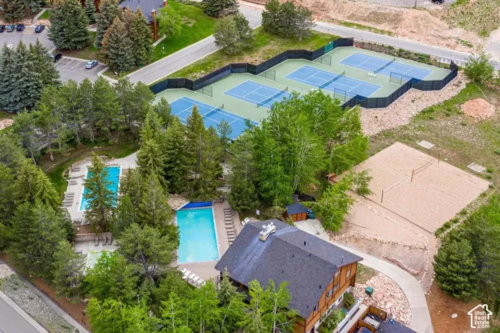 Expansive recreational grounds featuring two swimming pools, multiple tennis courts, a sand volleyball court, and mature landscaping