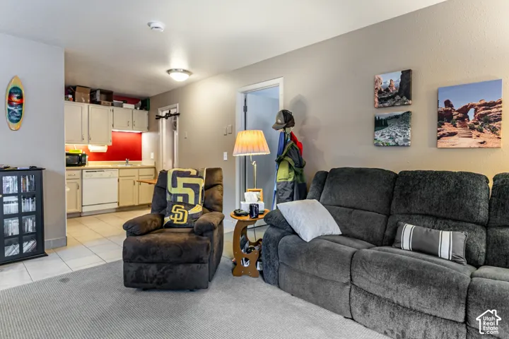 Open concept living area featuring a kitchen with white cabinetry and a red backsplash