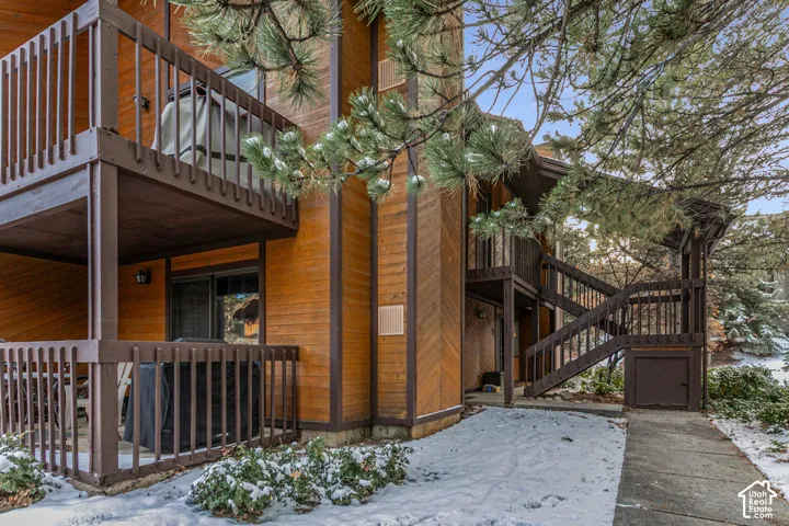 Multi-level exterior featuring wood siding and dark-stained wood railings