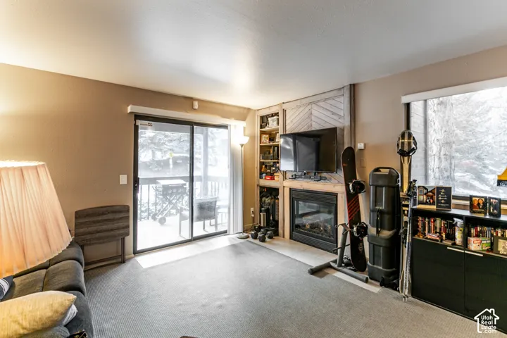 Living area featuring a floor-to-ceiling fireplace with a wood-plank accent wall and built-in shelving