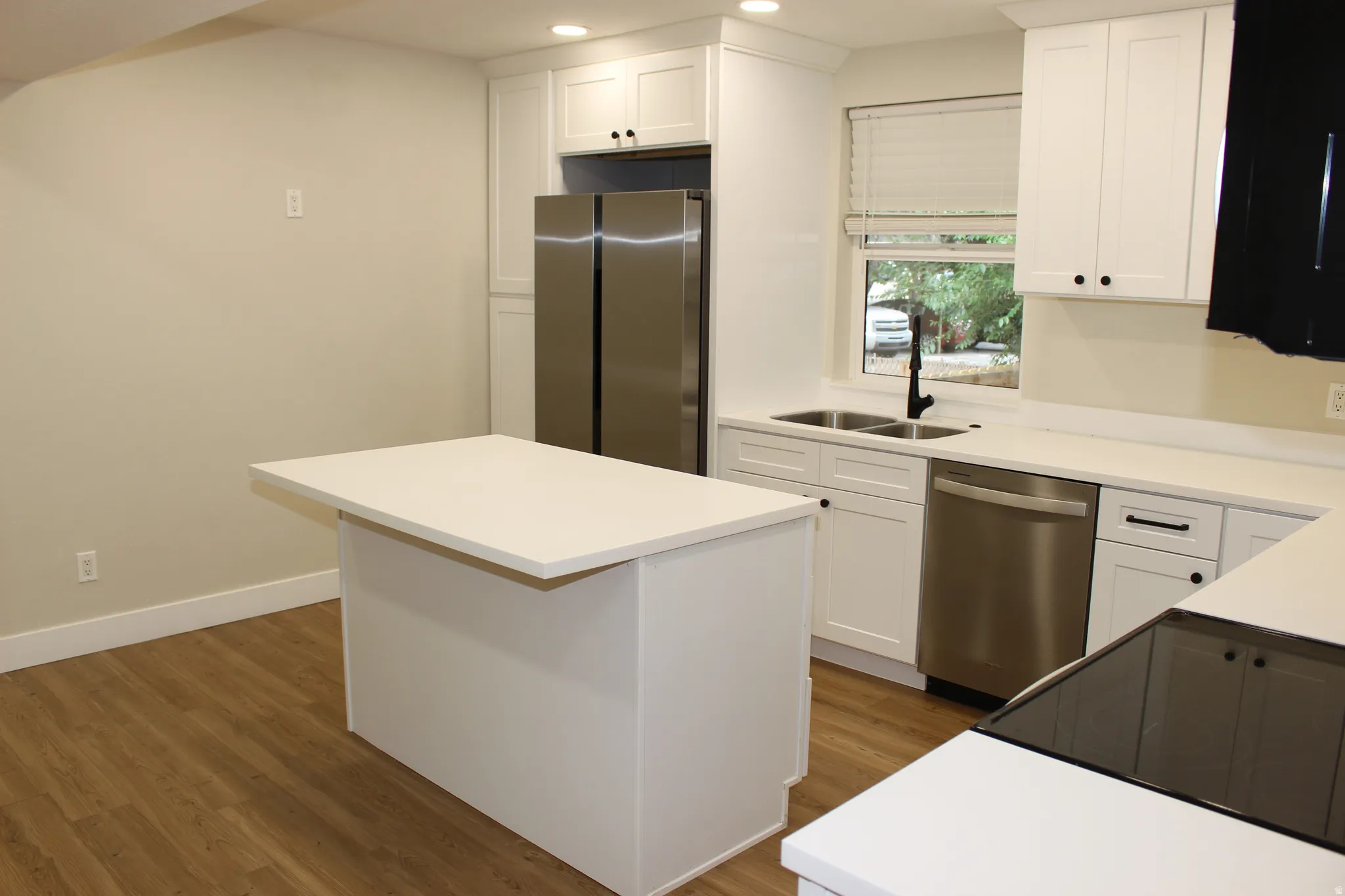 Modern kitchen featuring white shaker cabinetry and integrated stainless steel appliances