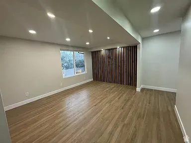 Open living area with a large window, and a decorative wood-slat accent wall