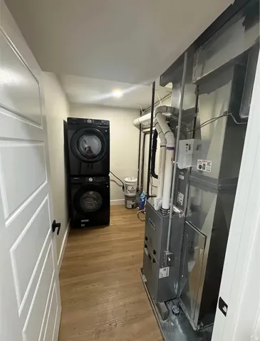 Dedicated utility area featuring wood-finish flooring and white walls