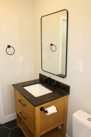 Bathroom vanity with an integrated sink, matte black faucet, and a rectangular framed mirror