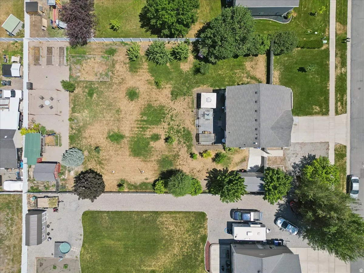 Expansive property featuring a gravel parking area, a large shed, and mature trees
