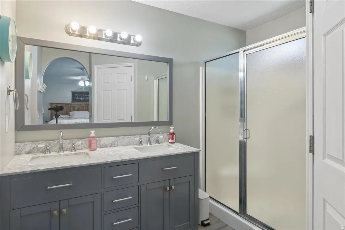 Dual sink vanity with stone-finish countertop, under-mount sinks, and chrome faucets