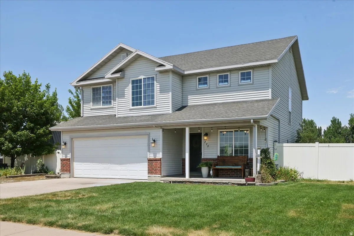 Two-story residence featuring light-colored siding and a covered front porch