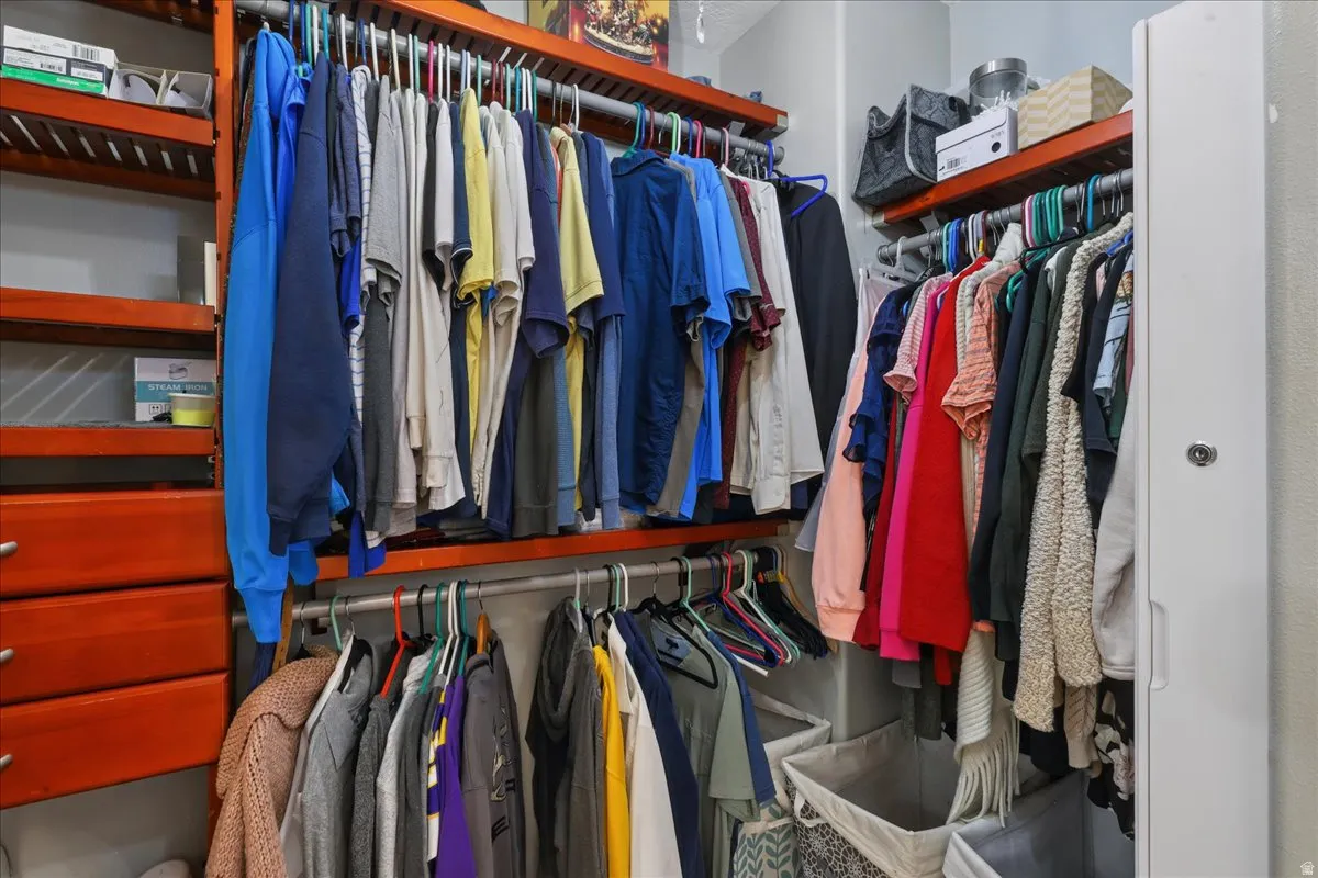 Custom closet organization system featuring rich wood-finish shelving and hanging rods