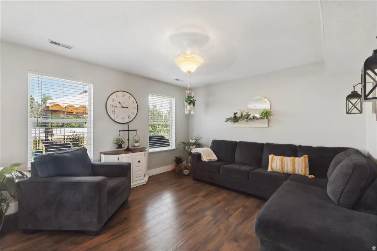 Living area featuring wood-finish flooring, light grey walls, and a ceiling light fixture