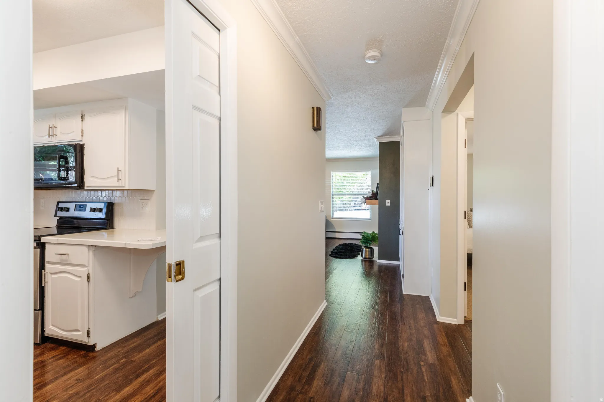 Hardwood-finish flooring throughout, crown molding, and a white six-panel pocket door