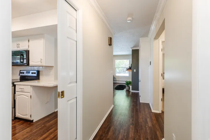 Hardwood-finish flooring throughout, crown molding, and a white six-panel pocket door