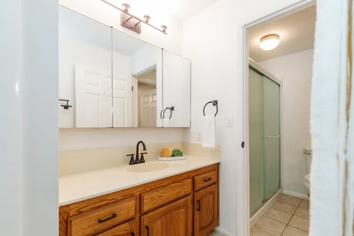 Bathroom vanity with a light wood-finish cabinet and a light-toned countertop