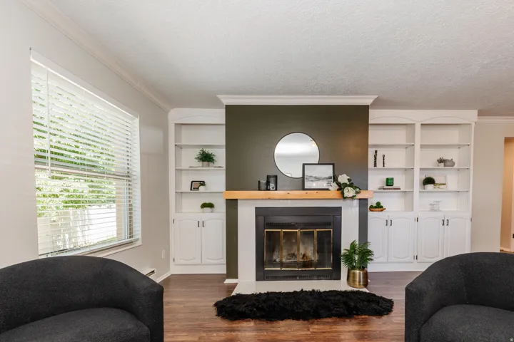 Central fireplace with a wood mantel and dark accent wall