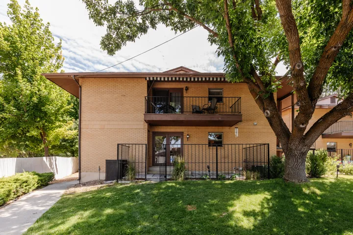 Brick exterior featuring a private upper balcony with iron railings and an awning