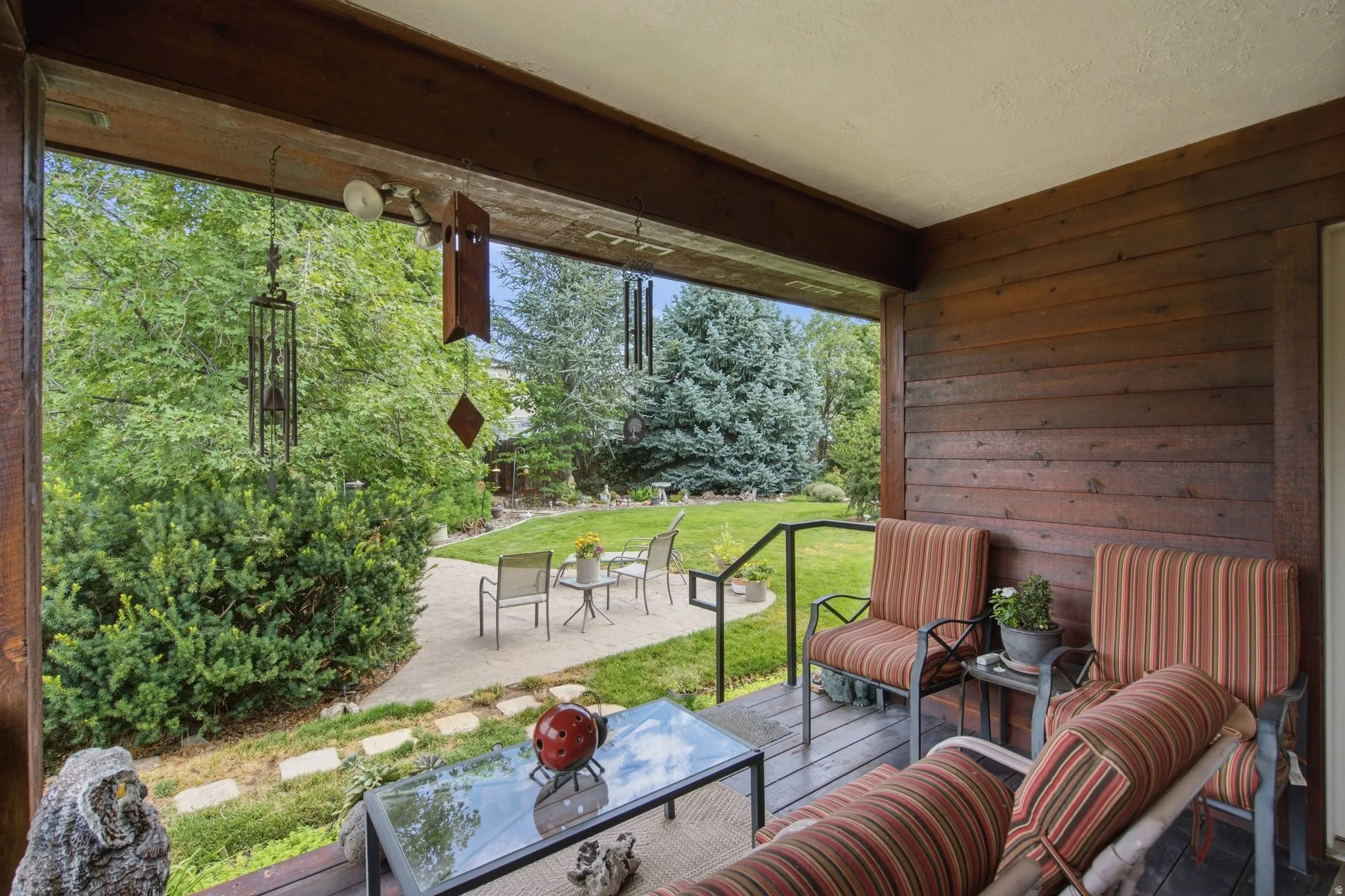 Covered deck with wood-plank flooring and a horizontal wood-paneled wall