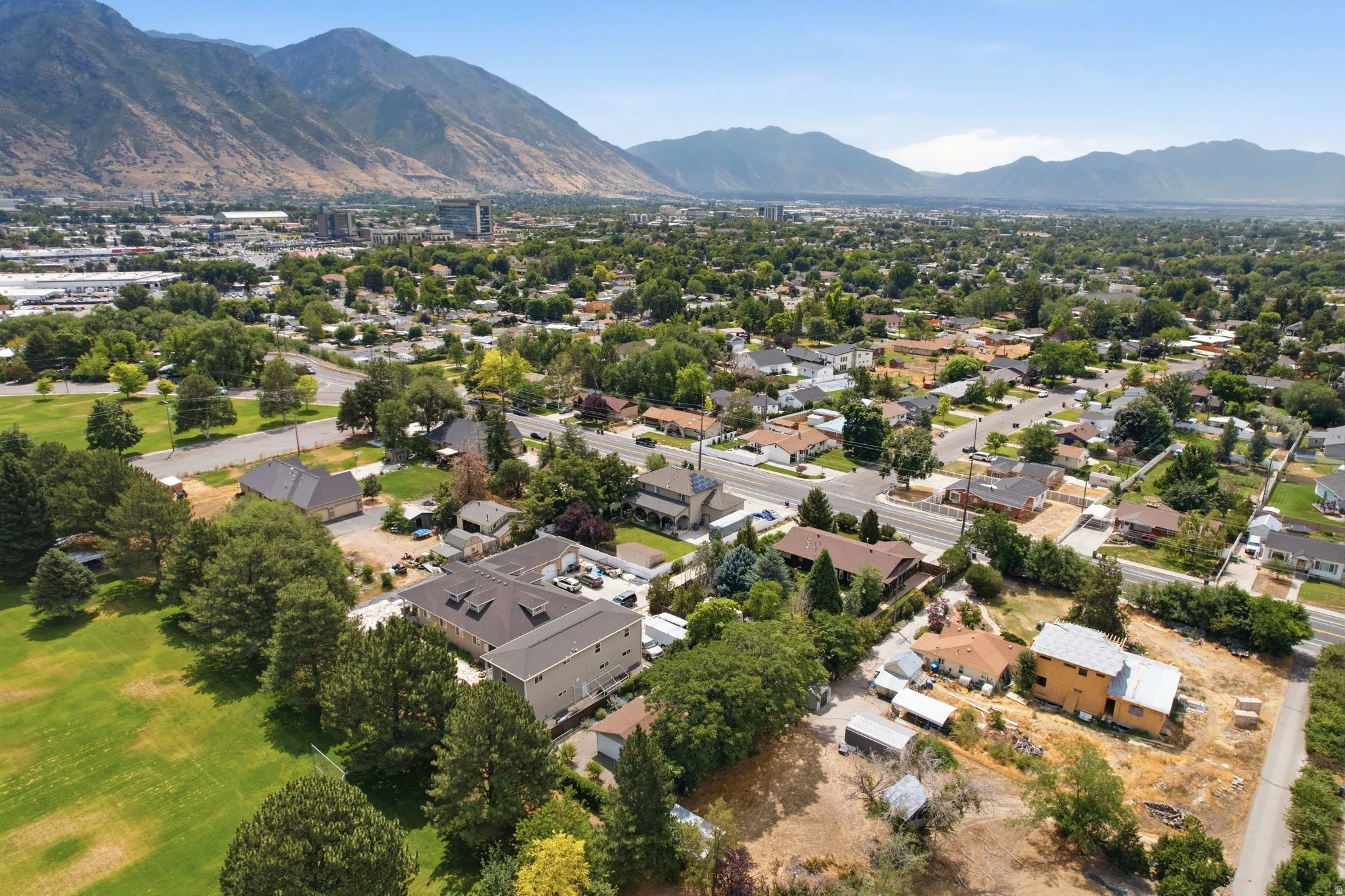 Aerial perspective highlighting the surrounding neighborhood with a mountainous backdrop