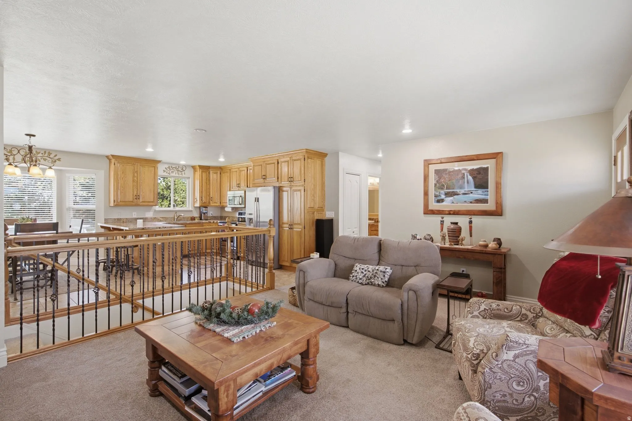 Open-concept living space featuring a carpeted floor, light-toned walls, and recessed lighting