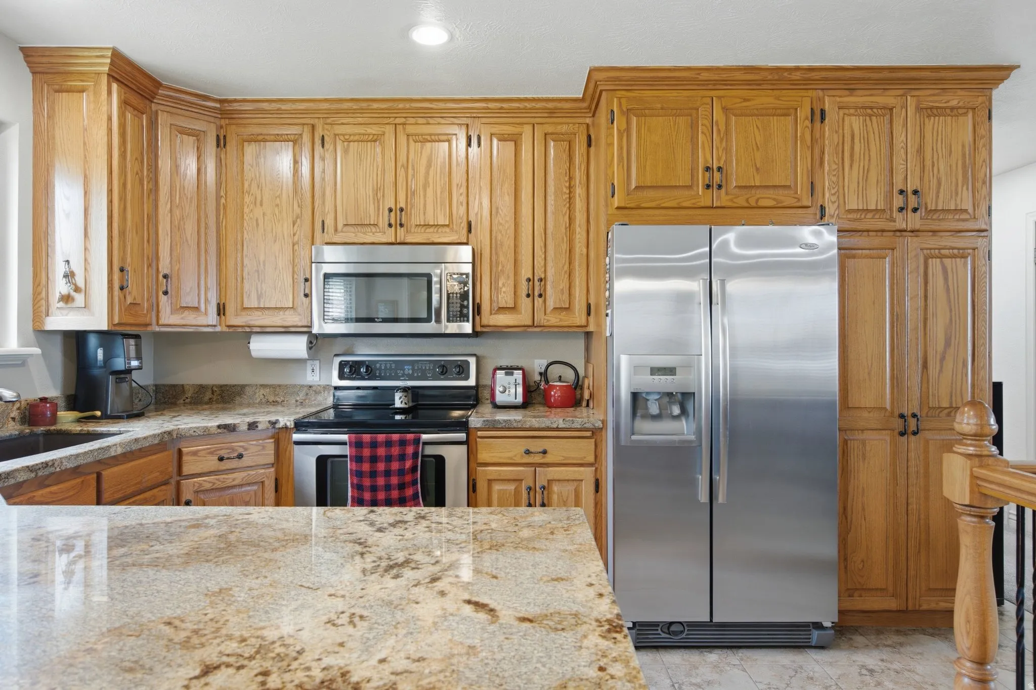 Kitchen featuring extensive wood cabinetry, stainless steel appliances, and granite countertops