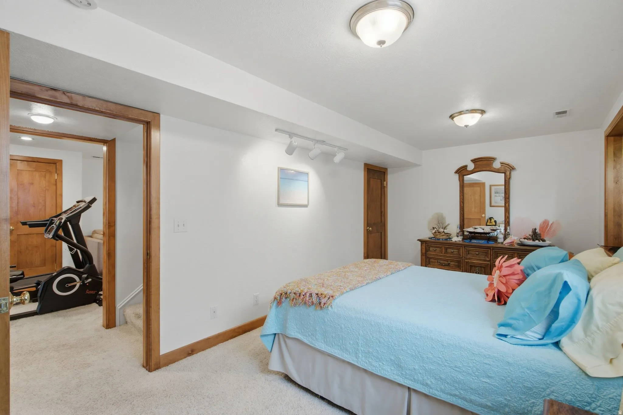 Carpeted room featuring white walls, wood trim, and a ceiling-mounted light fixture