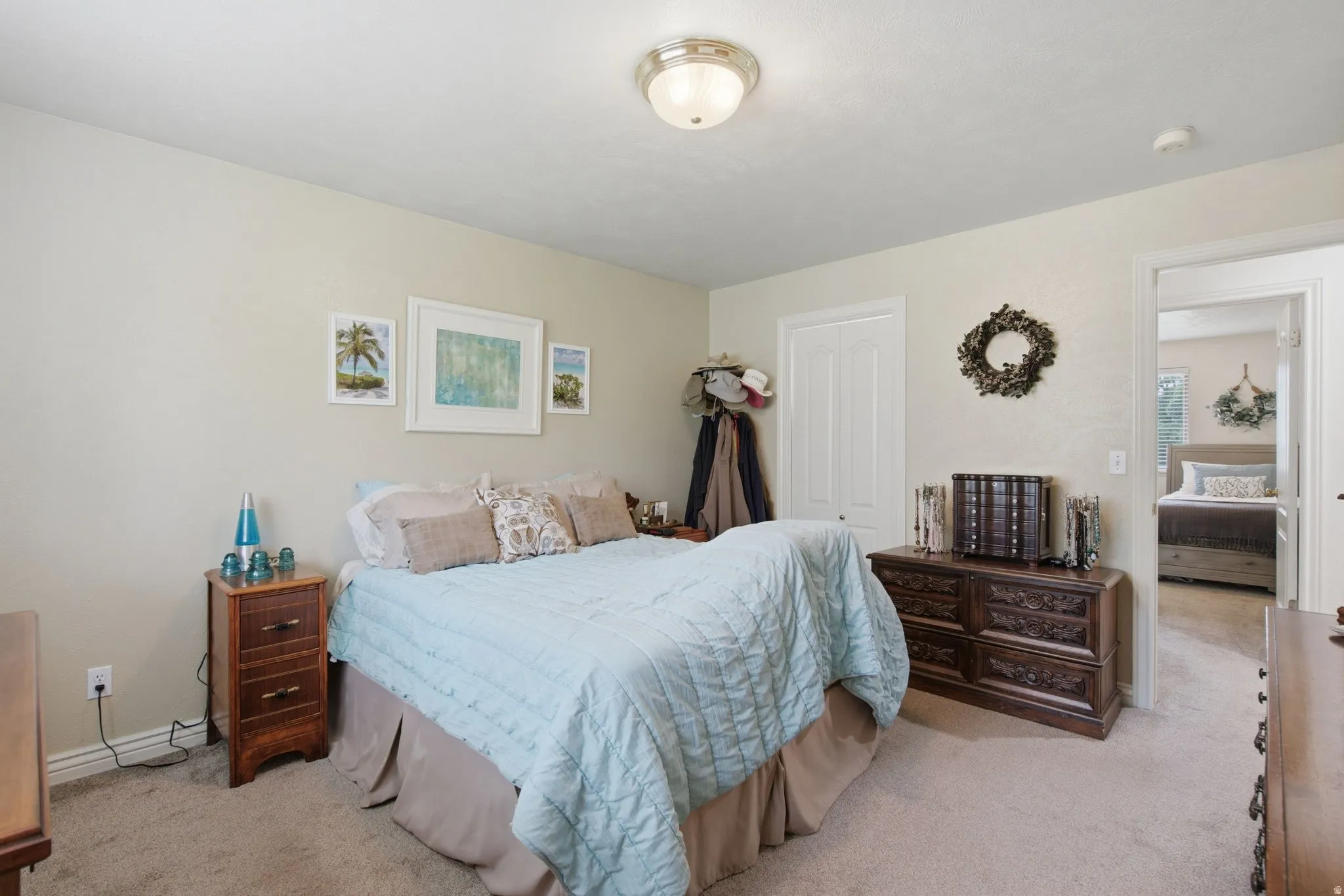 Neutral tone wall finishes, ceiling-mounted light fixture, and plush carpet flooring