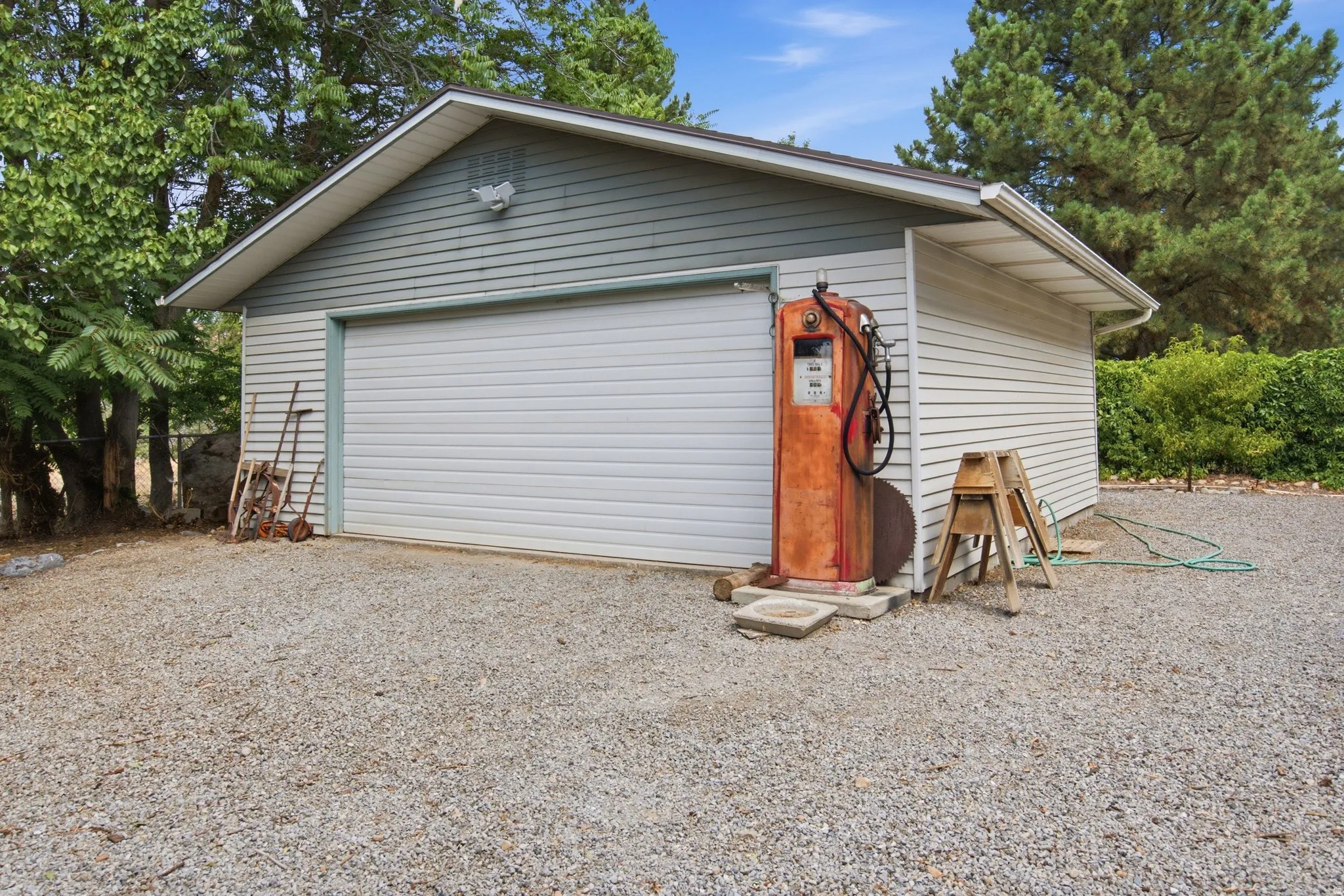 Detached garage featuring horizontal siding, a pitched roof, and a large roll-up door