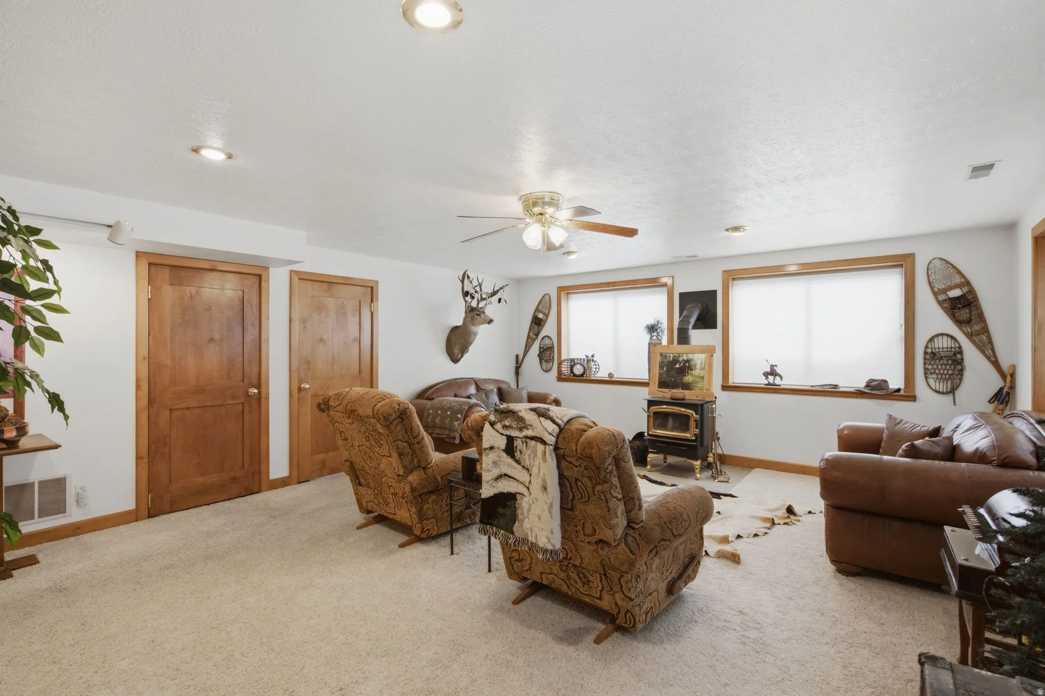 Spacious living area featuring light-colored carpeting and bright white walls