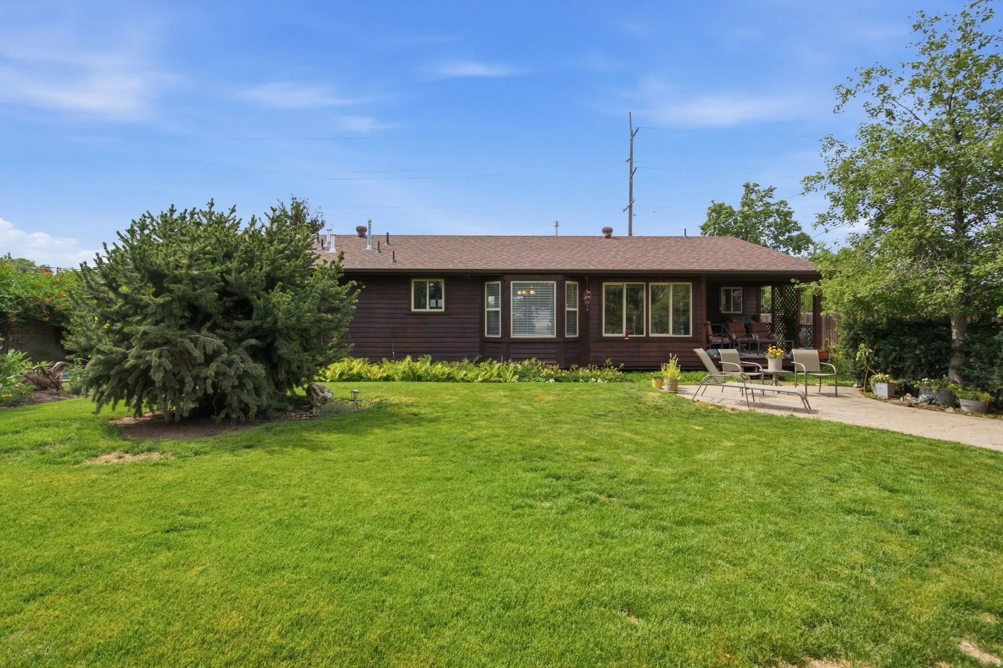 Ranch-style exterior with rich wood-finish siding and a brown shingle roof