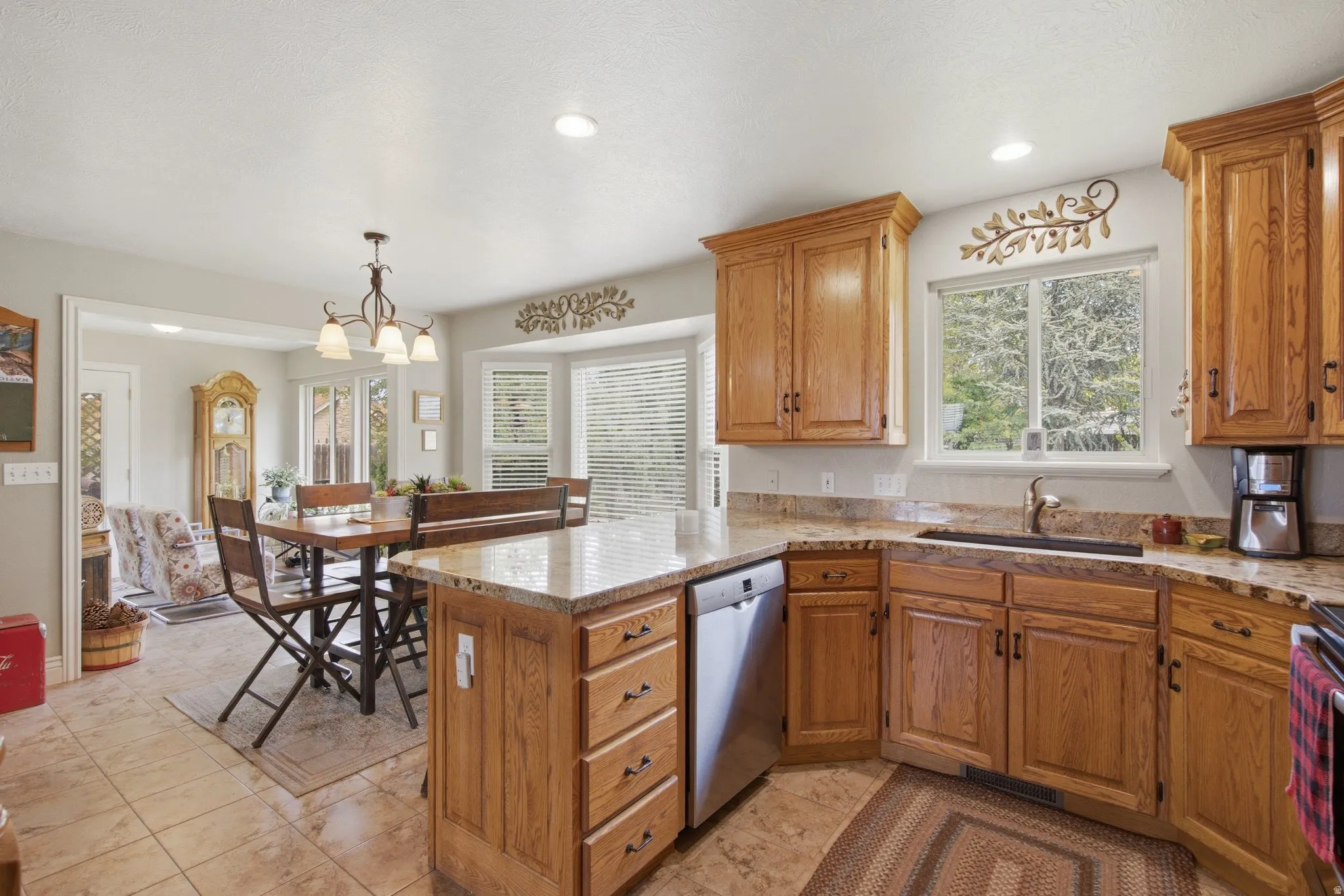 Kitchen featuring wood cabinetry, light-toned countertops, tile flooring, and recessed lighting