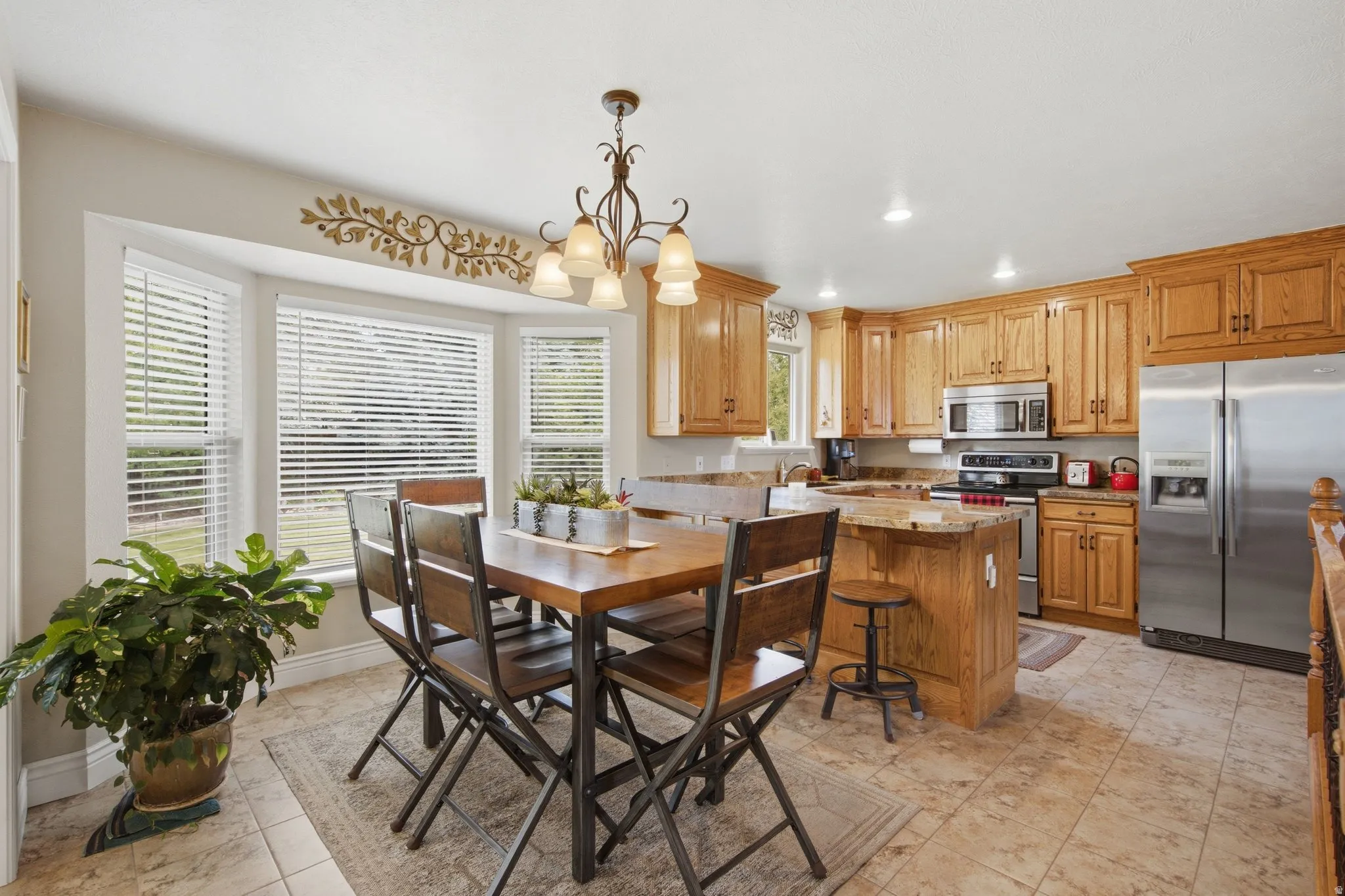 Kitchen featuring wood cabinetry, stainless steel appliances, and a central island with countertop seating