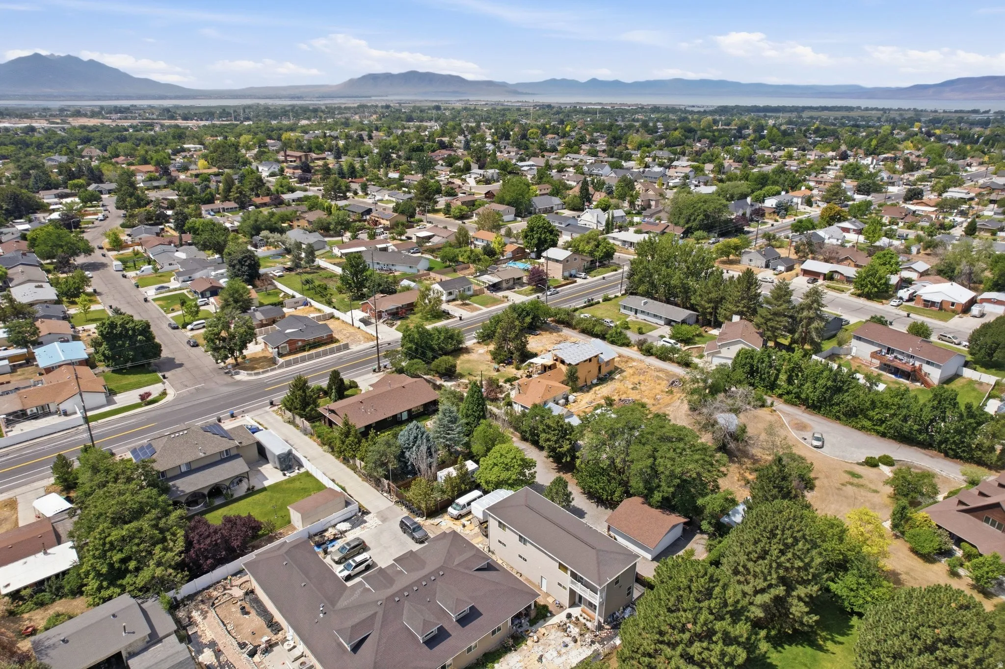 Expansive residential area featuring established homes, mature trees, and a distant mountain range backdrop