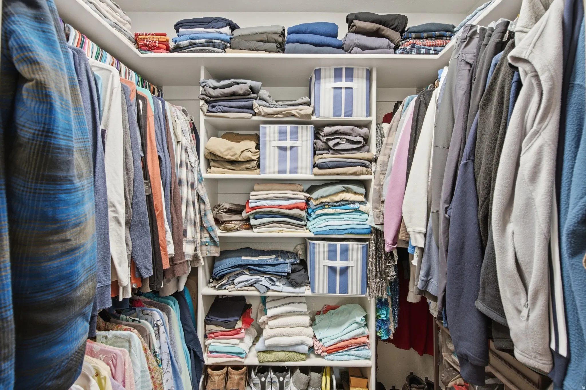 Expansive custom closet featuring built-in shelving, multiple hanging rods, and integrated storage compartments