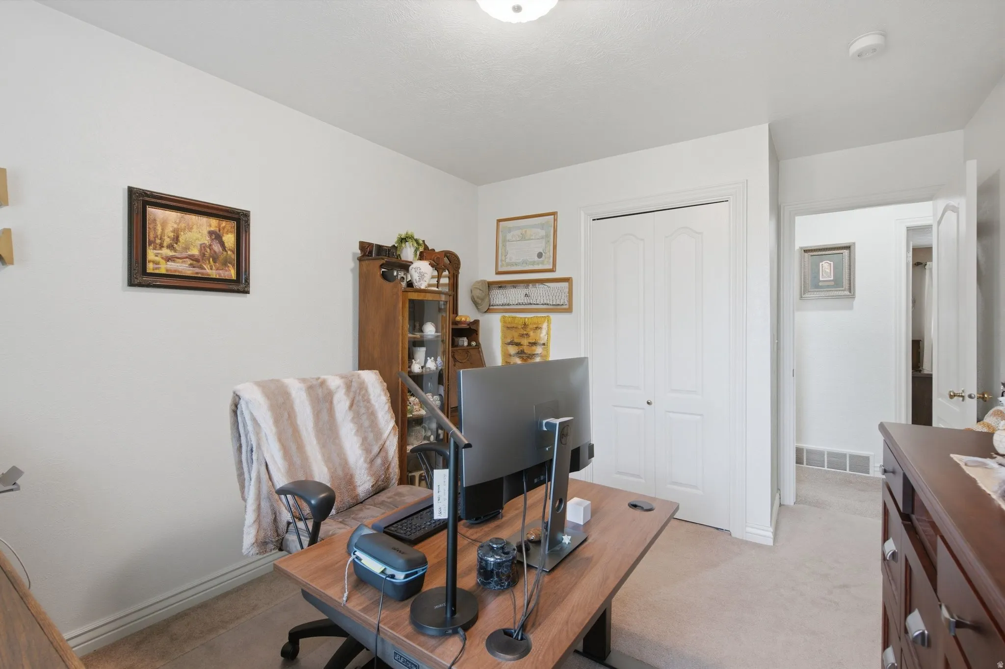 Carpeted room with a ceiling-mounted light fixture, white walls, and white baseboards