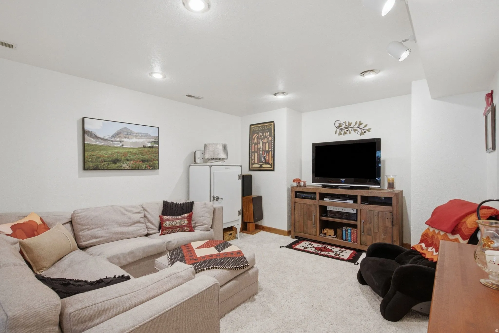 Carpeted room featuring recessed lighting, track lighting, and a built-in media console