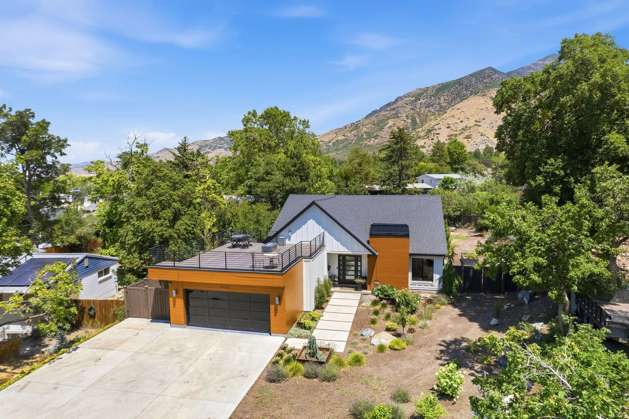 Modern architectural residence featuring a two-car garage, rooftop deck, and a distinct front entry