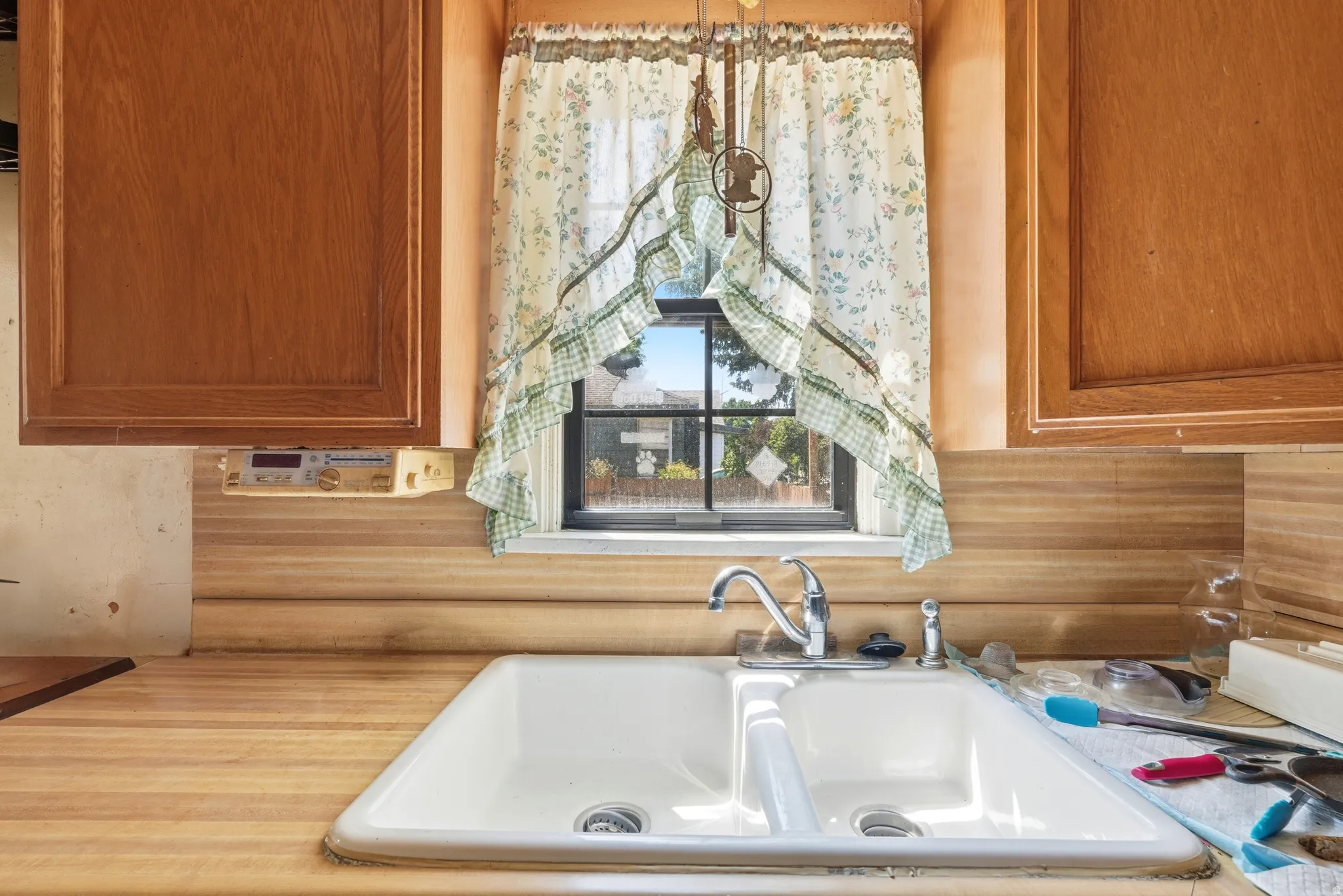 Double basin sink with chrome faucet, set into wood-finish countertops