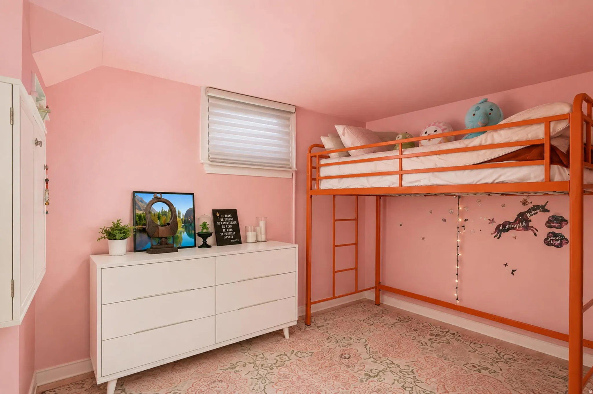Room featuring a window with privacy blinds, built-in wall cabinetry, and a patterned area rug