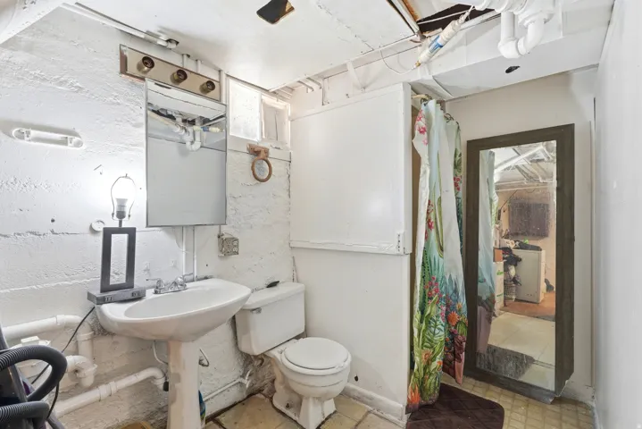 Pedestal sink with chrome fixtures and a vanity mirror