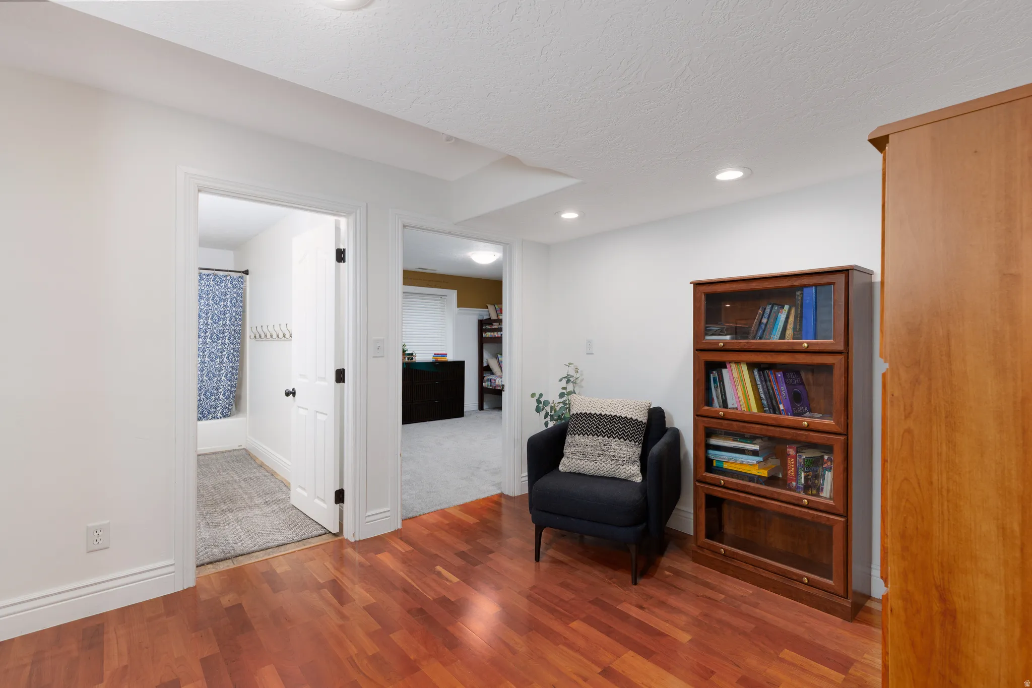 Hardwood flooring throughout a bright interior with white walls, recessed lighting, and white trim