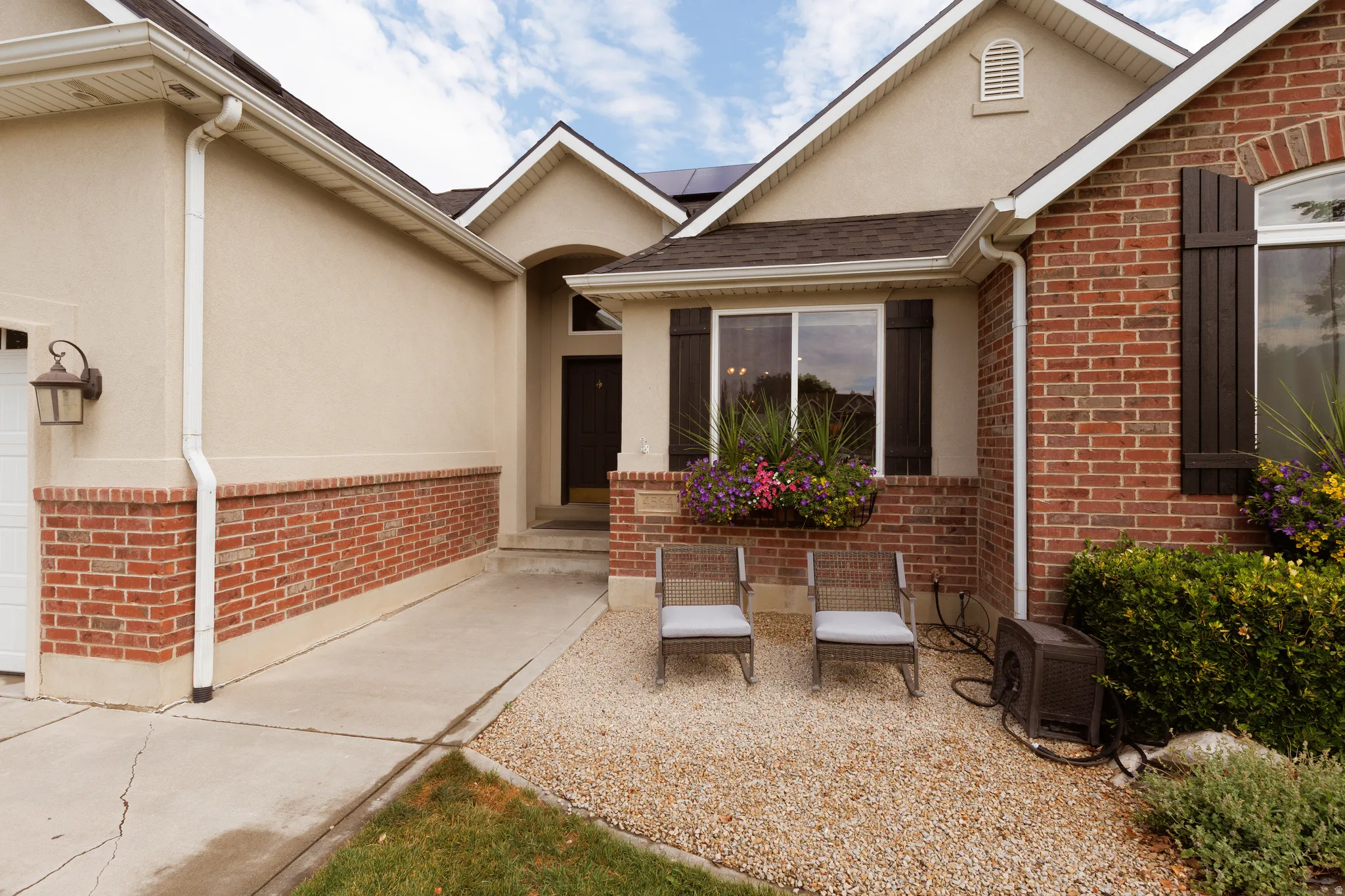 Brick and stucco exterior with dark wood window shutters