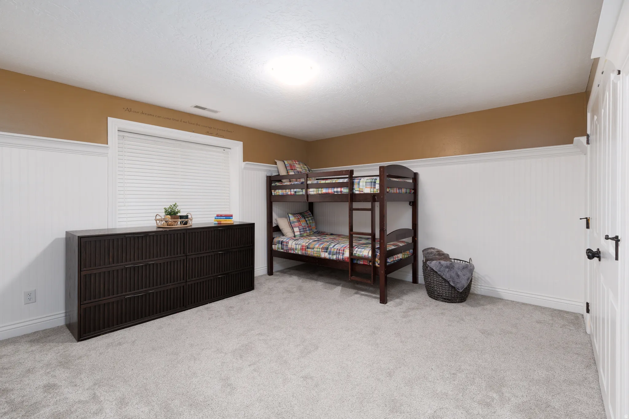 Room featuring light gray carpeting, white beadboard wainscoting, and a window with white blinds