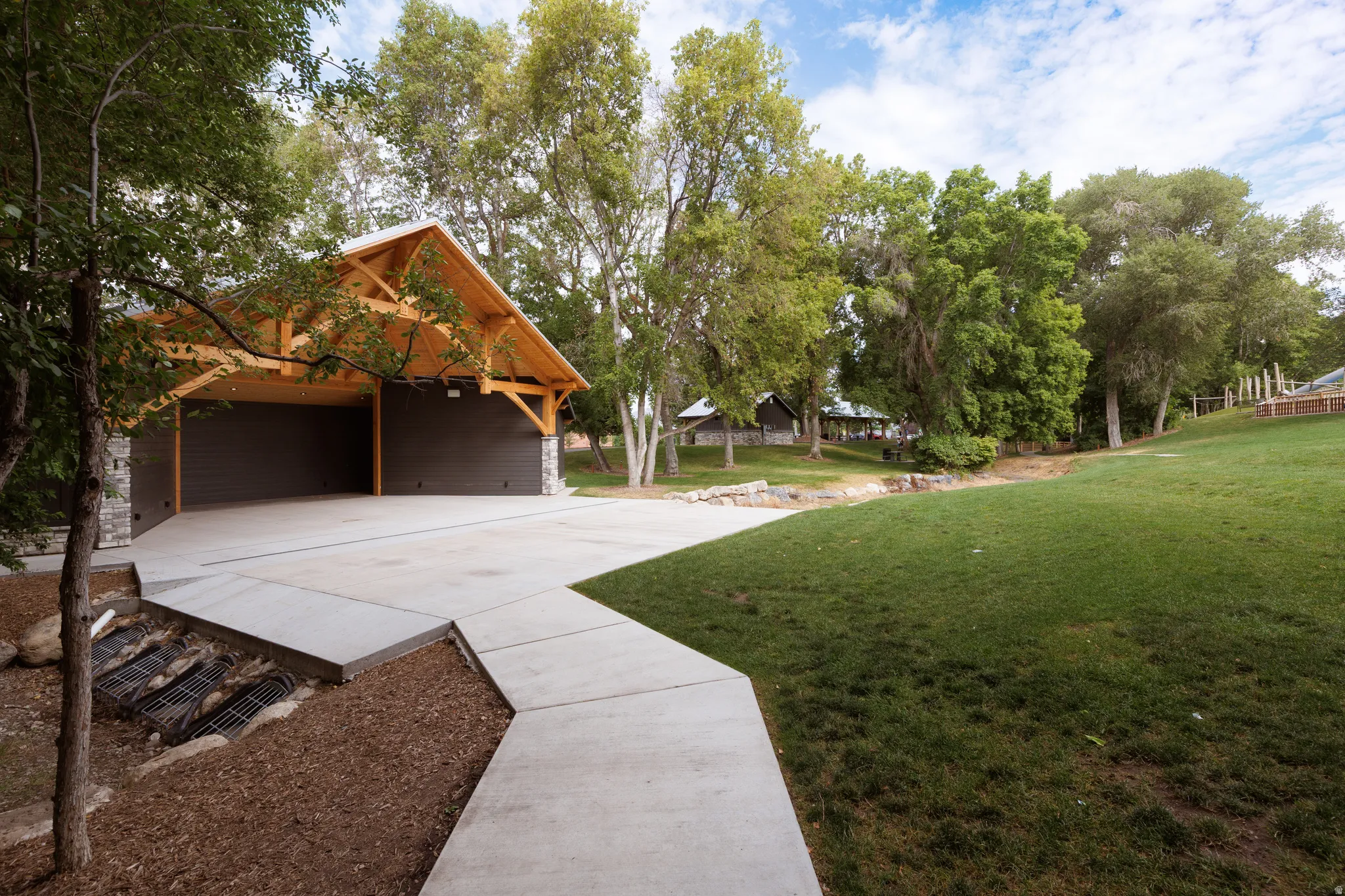 Exposed timber framing and stone accents define this two-stall detached carport